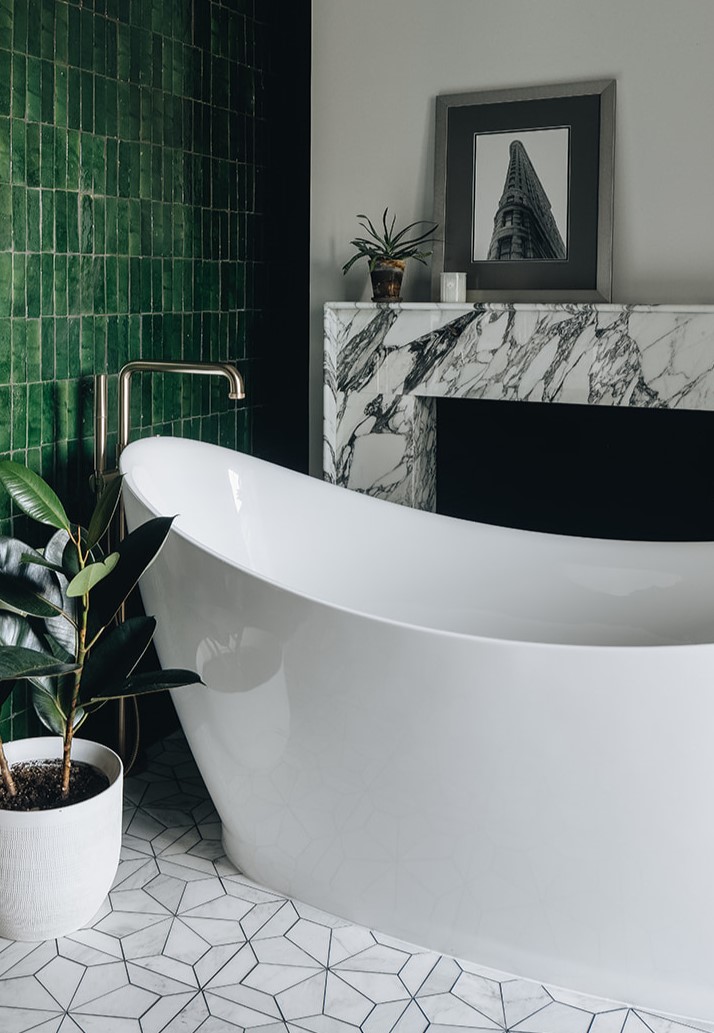 modern bathtub with green tiles and granite backsplash