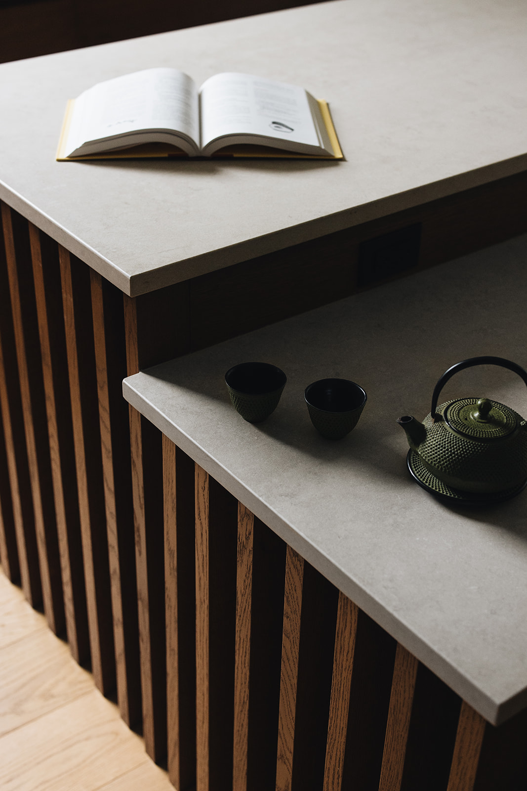 Oak slat rib detail on kitchen island and a book on the counter