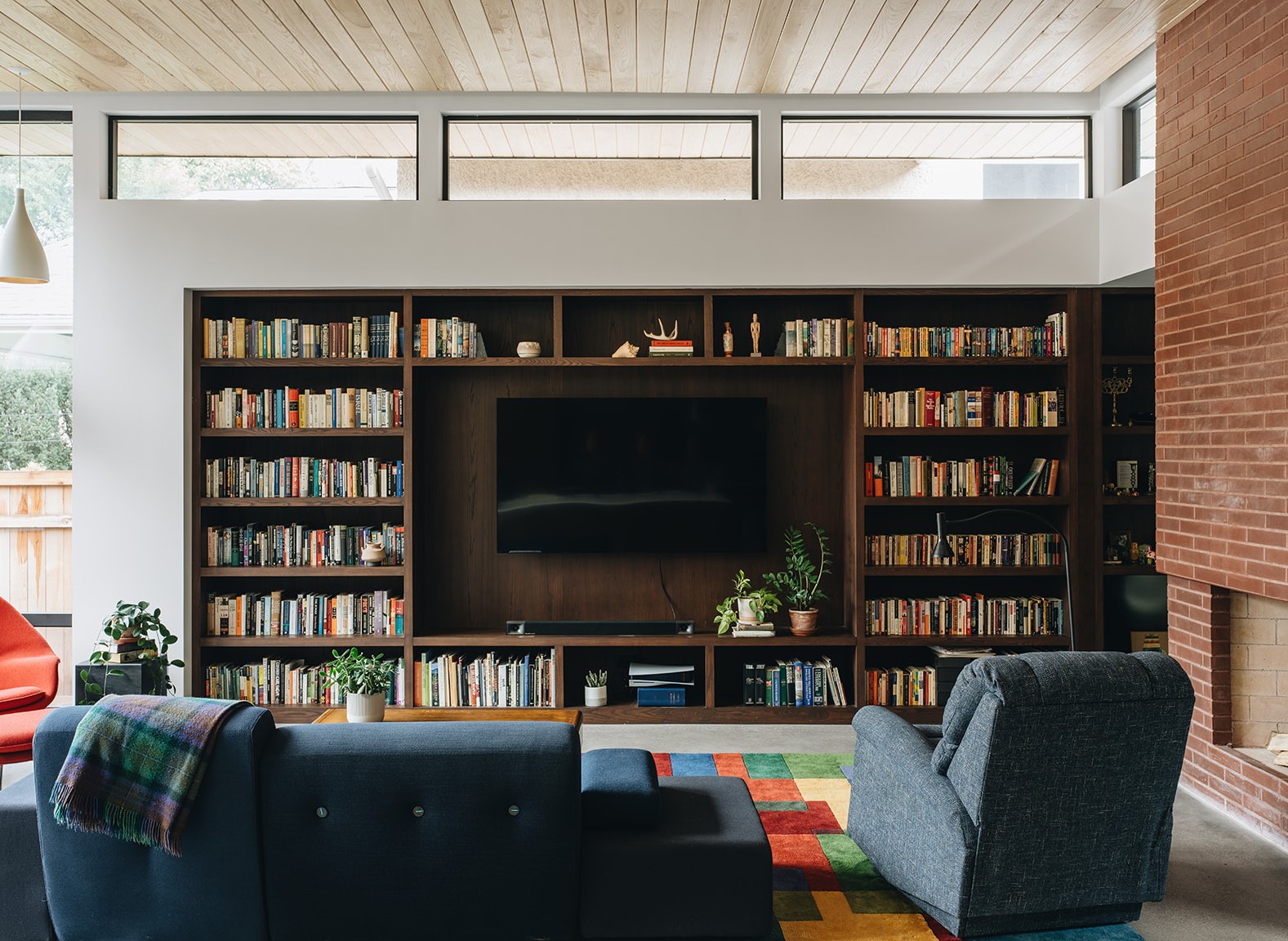 large entertaining living room with a large bookshelf surrounding a tv