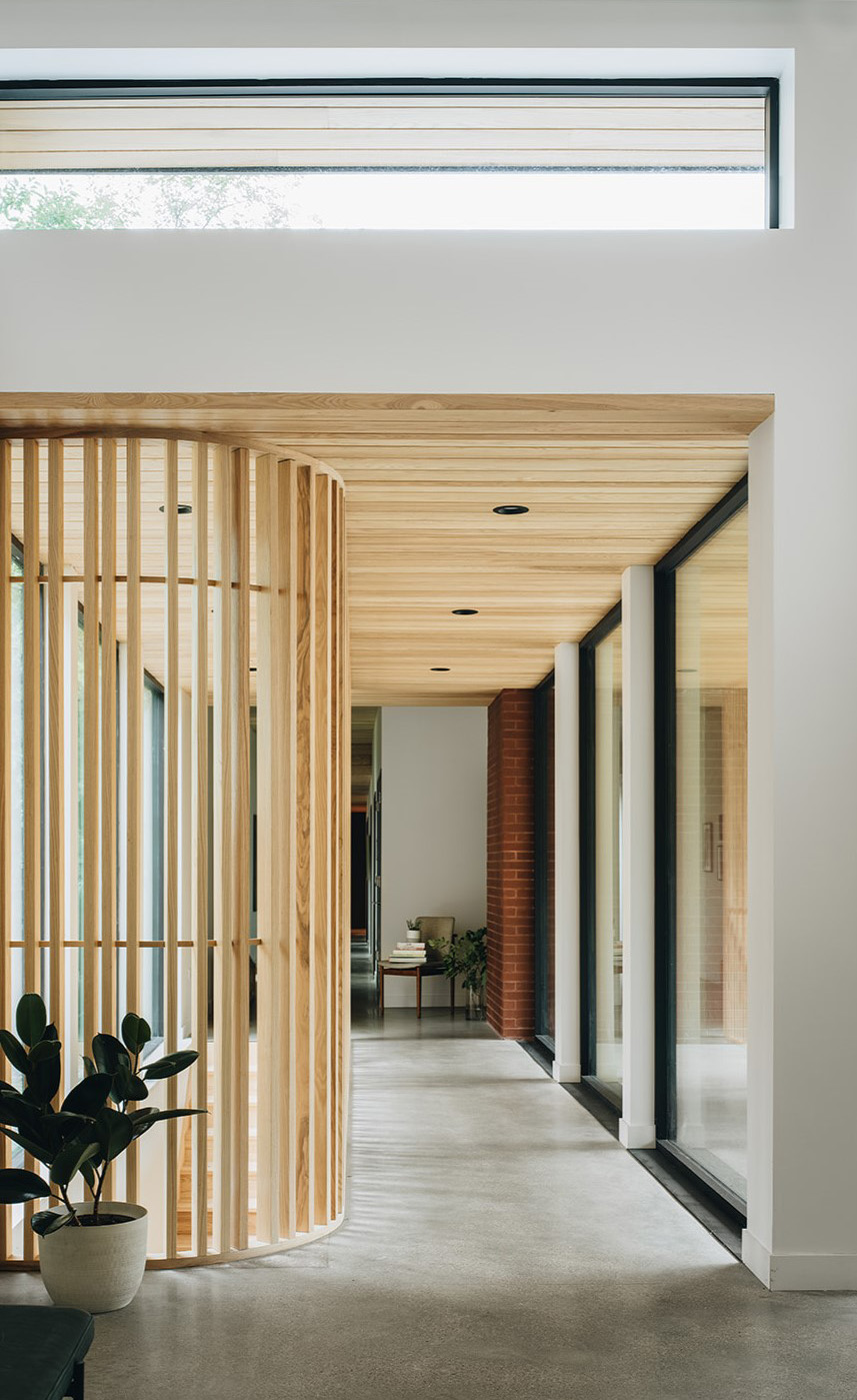 hallway with wooden accents leading to a stairwell