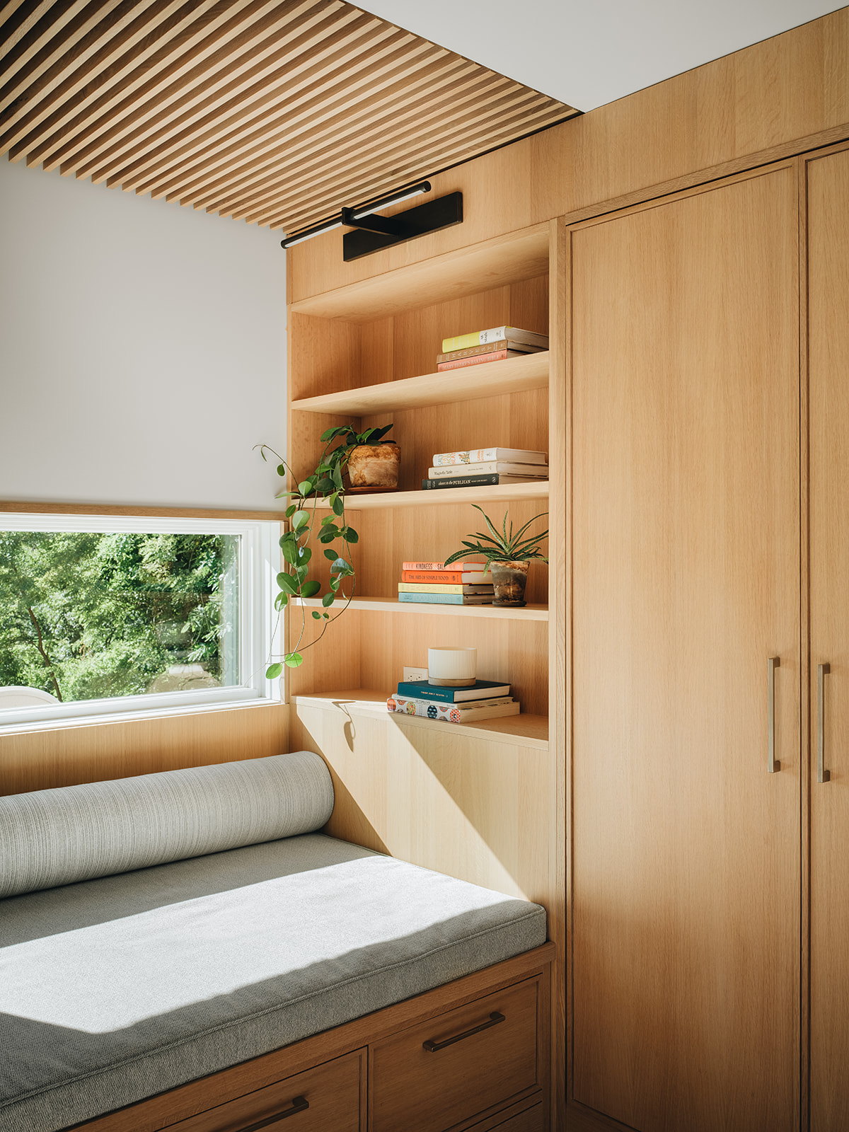 Reading nook with shelving and cabinetry to store books