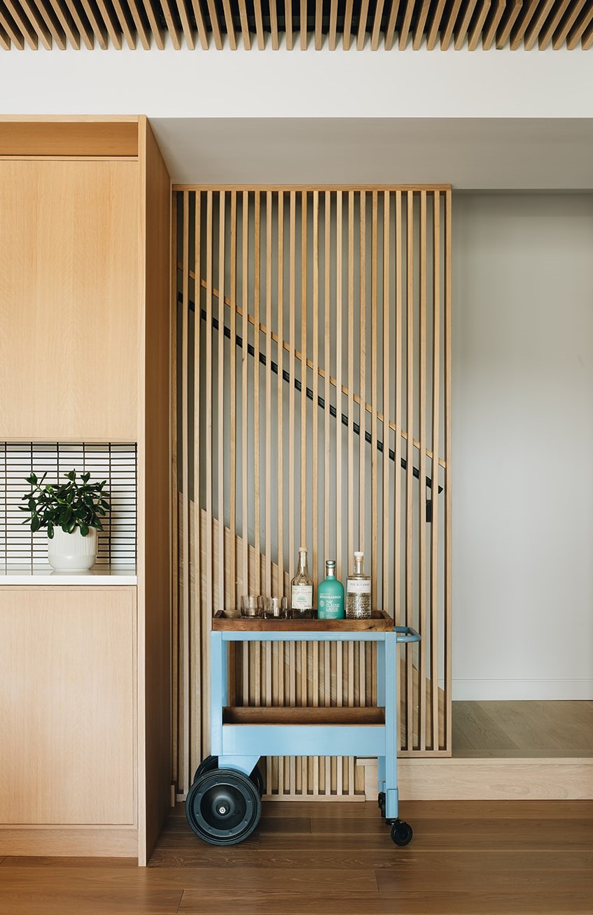 bottom of a staircase with a small rolling cart for drinks